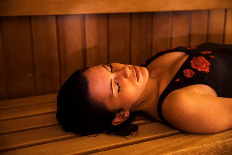Femme en maillot de bain se relaxant dans un sauna