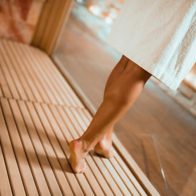 Jambes nus qui marchent vers un sauna